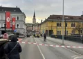 Varias personas observan una zona acordonada donde un hombre apuñaló a varias personas en la ciudad de Villach, en el sur de Austria, el 15 de febrero de 2025. (Wiesflecker/Kleine Zeitung vía AP)