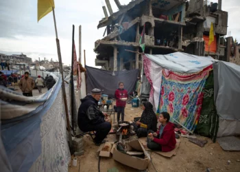 Una familia palestina cocina en el fuego junto a su tienda de campaña, en una zona destruida en gran parte durante la guerra contra Hamás en Jabaliya, Franja de Gaza, el 11 de febrero de 2025. (Jehad Alshrafi/AP)