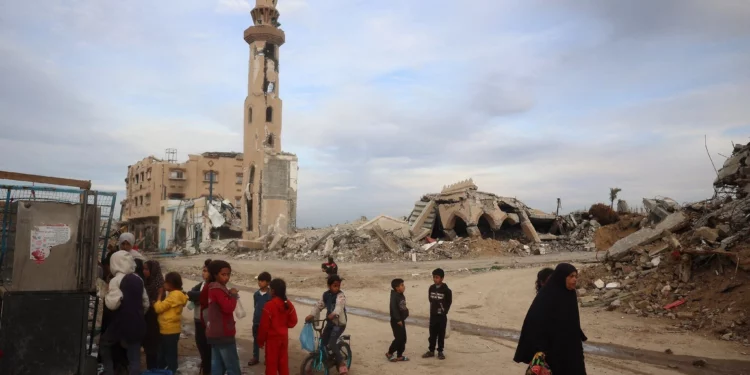 Palestinos se abastecen de agua junto a una mezquita destruida en el campo de refugiados de Nuseirat, en el centro de la Franja de Gaza, el 3 de marzo de 2025. (Eyad BABA / AFP)