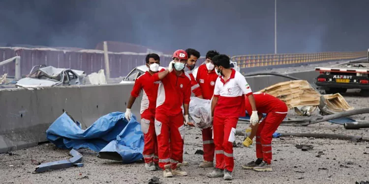 Una imagen proporcionada por la Media Luna Roja Iraní (RCS) el 27 de abril de 2025 muestra a los rescatistas llevando a una víctima lejos de la escena de una explosión que tuvo lugar un día antes en el muelle del puerto de Shahid Rajaee, al suroeste de Bandar Abbas, en la provincia iraní de Hormozgan (Media Luna Roja Iraní / AFP)