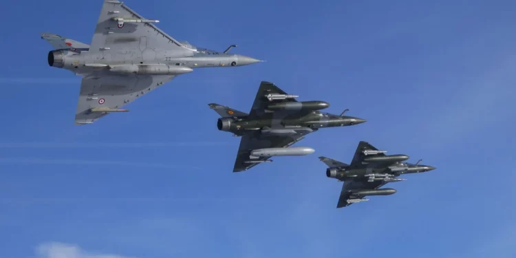 Dos Mirage 2000D RMV volando en formación con un Mirage 2000-5. El avión líder está equipado con dos misiles antiaéreos MICA IR, dos GBU-49, una cápsula de cañón CC422 de 30 mm y una cápsula de puntería TALIOS.