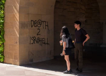 Estudiantes caminan junto a un grafiti que dice “Muerte a Israel” cerca de la oficina del presidente de la Universidad de Stanford en Palo Alto, California, el 5 de junio de 2024. (Foto AP/Nic Coury)