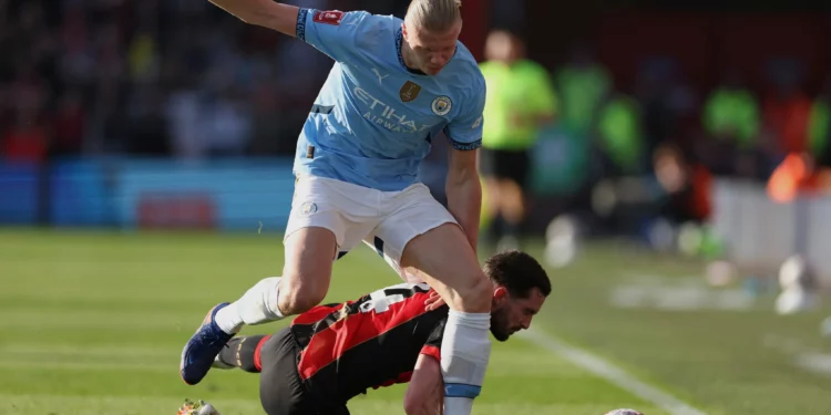 El futbolista noruego Erling Haaland (arriba), del Manchester City, disputa el balón con Lewis Cook, del Bournemouth, durante el partido de cuartos de final de la Copa FA inglesa entre el Bournemouth y el Manchester City en el estadio Vitality de Bournemouth, Inglaterra, el 30 de marzo de 2025. (Ian Walton/AP)