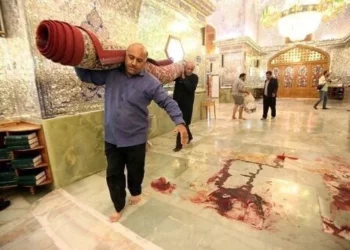 Trabajadores limpian la escena tras un ataque armado en el mausoleo de Shah Cheragh, en la ciudad iraní de Shiraz, en el que murieron 15 personas, el 26 de octubre de 2022. (AGENCIA DE NOTICIAS ISNA/AFP)