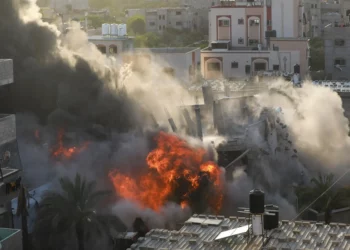 Una imagen muestra una casa siendo alcanzada por un ataque aéreo israelí en la ciudad de Gaza el 13 de mayo de 2023. (Majdi Fathi/AFP)