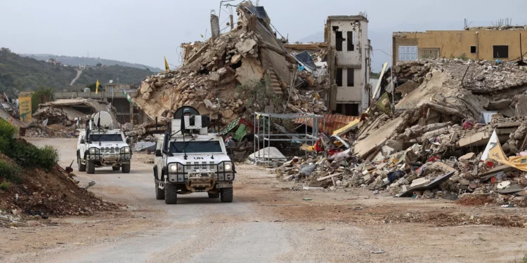 Las fuerzas de paz de las Naciones Unidas conducen vehículos de la Fuerza Provisional de las Naciones Unidas en el Líbano (FPNUL) junto a edificios destruidos mientras patrullan la aldea de Kfar Kila, en el sur del Líbano, cerca de la frontera con Israel, el 6 de abril de 2025. (Rabih DAHER / AFP)