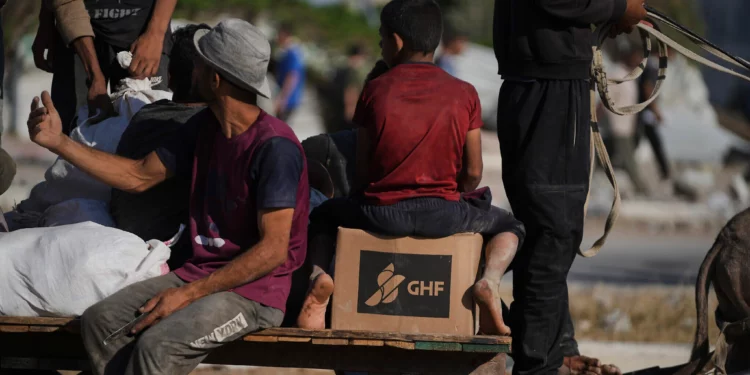 Palestinos llevan paquetes de ayuda humanitaria cerca del centro de distribución de la Fundación Humanitaria de Gaza, operado por la organización respaldada por Estados Unidos, en Jan Yunis, sur de la Franja de Gaza, el 26 de junio de 2025. (Foto AP/Abdel Kareem Hana)