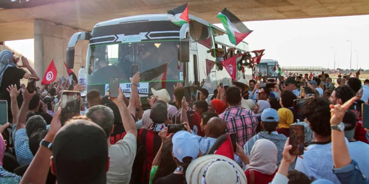 La gente aplaude cuando un convoy de autobuses compuesto por activistas, abogados y profesionales médicos del norte de África parte de Túnez a Gaza para romper el bloqueo de Israel sobre el territorio gobernado por Hamás, en Gabes, Túnez, el 9 de junio de 2025. (AP Foto)
