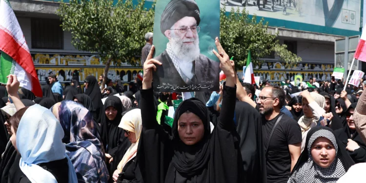 Un iraní lleva un retrato del líder supremo de Irán, el ayatolá Alí Jamenei, durante una manifestación antiisraelí en Teherán el 20 de junio de 2025. (AFP)