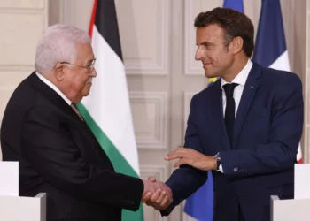 El presidente francés, Emmanuel Macron (der.), estrecha la mano del presidente de la Autoridad Palestina, Mahmoud Abás, durante una conferencia de prensa en el Palacio del Elíseo en París, el 20 de julio de 2022. (Ludovic MARIN / POOL / AFP)