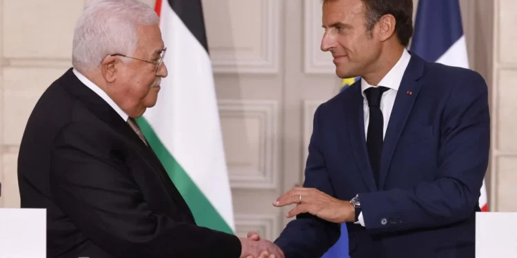 El presidente francés, Emmanuel Macron (der.), estrecha la mano del presidente de la Autoridad Palestina, Mahmoud Abás, durante una conferencia de prensa en el Palacio del Elíseo en París, el 20 de julio de 2022. (Ludovic MARIN / POOL / AFP)