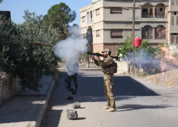 Un miembro de las fuerzas de seguridad sirias dispara un arma lanzada desde el hombro en medio de enfrentamientos en la ciudad sureña de Sweida el 16 de julio de 2025. (Omar HAJ KADOUR / AFP)