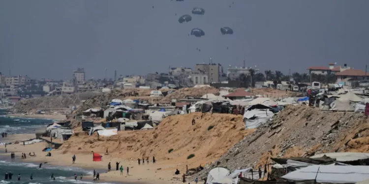 La ayuda humanitaria se lanza desde el aire a los palestinos sobre el centro de la Franja de Gaza, como se ve desde Jan Yunis el 28 de julio de 2025. (AP Foto/Abdel Kareem Hana)