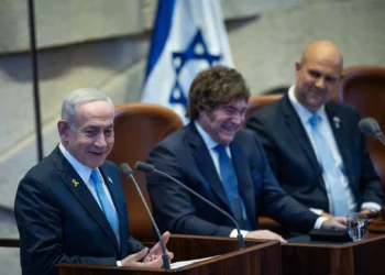 El primer ministro Benjamín Netanyahu (izquierda) habla junto al presidente argentino Javier Milei (centro) en la Knéset en Jerusalén, el 11 de junio de 2025. (Yonatan Sindel/Flash90)