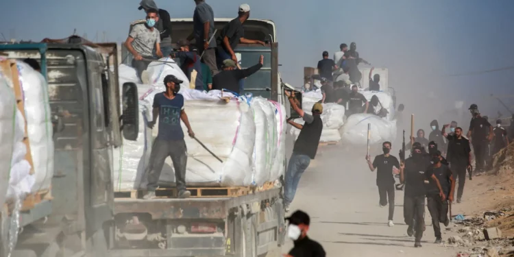 Voluntarios de familias palestinas custodian camiones con ayuda humanitaria que ingresaron a la Franja de Gaza desde el cruce fronterizo de Zikim, el 25 de junio de 2025. (Bashar TALEB / AFP)