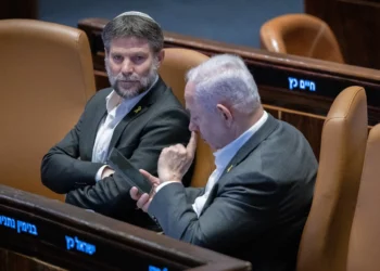 El ministro de Finanzas, Bezalel Smotrich (izquierda), y el primer ministro, Benjamín Netanyahu, asisten a una votación en el pleno de la Knéset, Jerusalén, el 31 de diciembre de 2024. (Chaim Goldberg/Flash90)