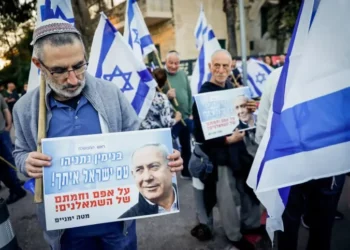 Un israelí asiste a una manifestación en apoyo a la reforma judicial planeada por el gobierno, frente a la Casa Presidencial en Jerusalén, el 3 de abril de 2023. Su pancarta dice: “Benjamín Netanyahu, el pueblo de Israel está contigo, a pesar de la oposición de la izquierda”. (Erik Marmor/Flash90)