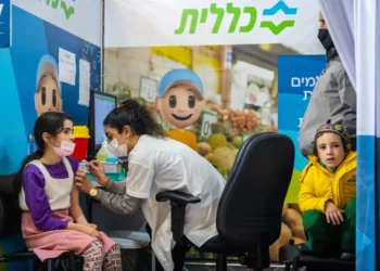 Una niña recibe una dosis de la vacuna contra la COVID-19 en un centro de vacunación Clalit en Jerusalén el 21 de diciembre de 2021. (Olivier Fitoussi/Flash90)