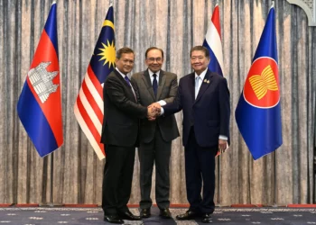 El primer ministro de Malasia, Anwar Ibrahim (centro), el primer ministro de Camboya, Hun Manet (izq.), y el primer ministro interino de Tailandia, Phumtham Wechayachai (der.), posan para fotos mientras se estrechan la mano tras una conferencia de prensa tras las conversaciones sobre un posible alto el fuego entre Tailandia y Camboya en Putrajaya, Malasia, el 28 de julio de 2025. (Mohd Rasfan / POOL / AFP)